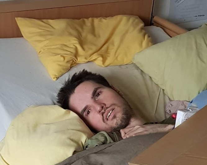 Close-up of Jonas resting on yellow pillows, gazing toward the camera.