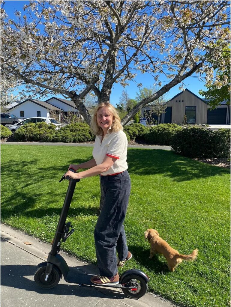 Woman on scooter with a dog.