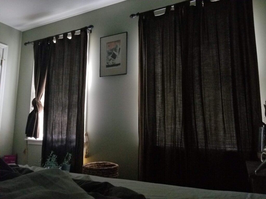 Tina's darkened bedroom with heavy curtains drawn, showing the sensory-controlled environment many ME/CFS patients require.