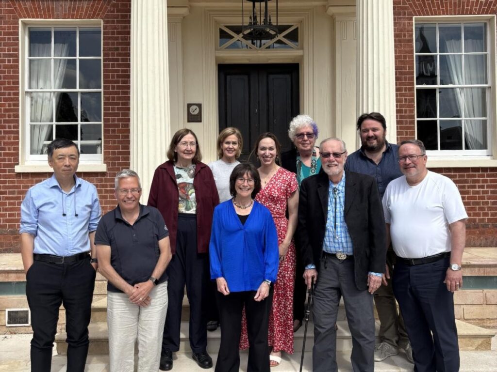 Group of researchers standing outside a historic brick building during a scientific meeting.